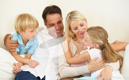 Image of Doting on their daughter. A loving family of four spending time together.