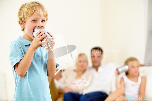 Image of Ill give her something to listen to. A little boy shouting loudly into a tin can connected to another that his sister is holding.