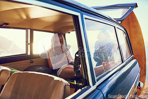 Image of Getting cozy in the backseat. Portrait of a happy young woman sitting inside a car during a roadtrip.