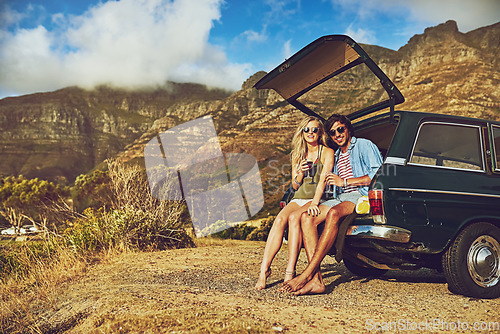 Image of Open hearts on the open road. Portrait of a happy young couple posing with their car on a roadtrip.