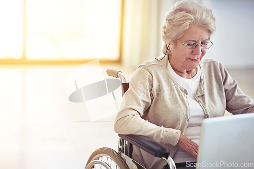 Image of Web browsing on wheels. a senior woman using a laptop while sitting in a wheelchair.