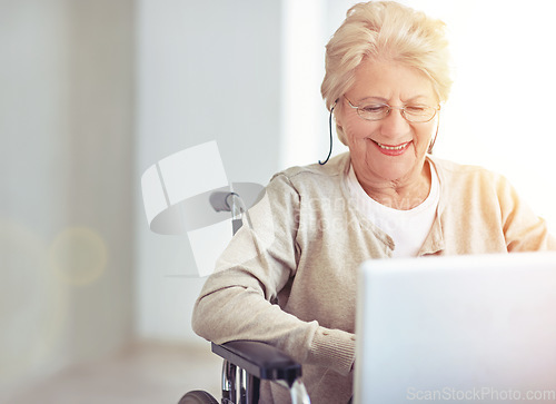 Image of Connecting with her family. a senior woman using a laptop while sitting in a wheelchair.