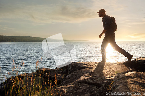 Image of Every moment is special when youre out hiking. a man wearing his backpack while out for a hike on a coastal trail.