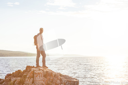 Image of Hiking is undoubtedly a fun and rewarding pastime. a man wearing his backpack while out for a hike on a coastal trail.