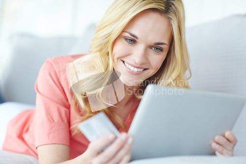 Image of Doing all her shopping via the web. a beautiful young woman using her digital tablet and credit card to shop online.