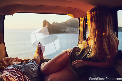 Image of Ocean as far as the eye can see. Rearview shot of a young couple relaxing inside their car during a roadtrip.