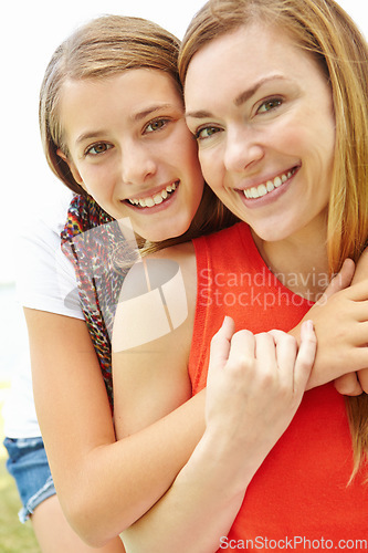 Image of My mother is my best friend. Smiling mother and daughter embracing while outdoors.