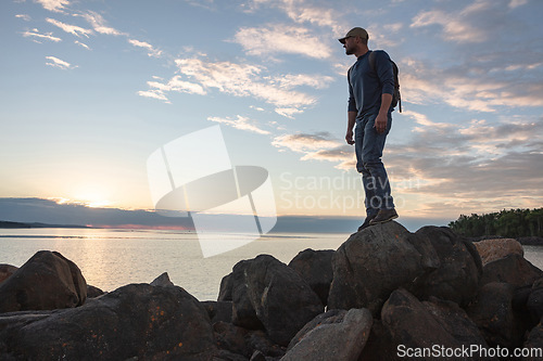 Image of If you want to see beautiful places, go hike. a man wearing his backpack while out for a hike on a coastal trail.