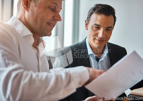 Image of Deciding on the best deal. two mature businessmen discussing paperwork in a corporate office.