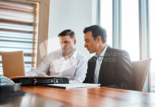 Image of Will your idea stand apart. two businessmen having a discussion while sitting by a laptop.