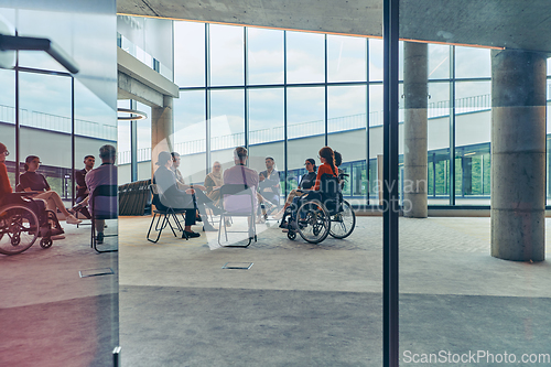 Image of A diverse group of young business entrepreneurs gathered in a circle for a meeting, discussing corporate challenges and innovative solutions within the modern confines of a large corporation