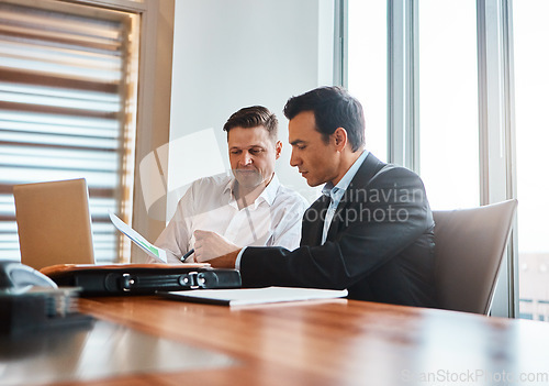 Image of Were taking our business global. two mature businessmen discussing paperwork in a corporate office.