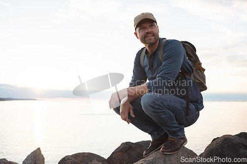 Image of I get to see amazing sights while out hiking. a man wearing his backpack while out for a hike on a coastal trail.