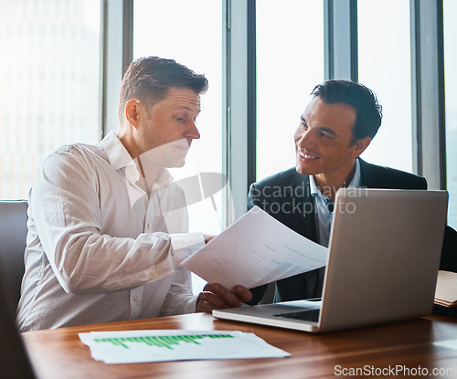 Image of Are you happy with our agreement. two businessmen having a discussion while sitting by a laptop.