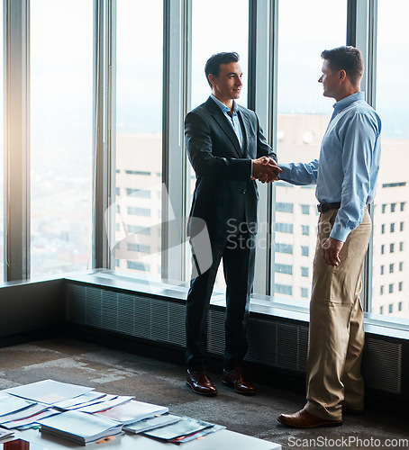 Image of Dreams and dedication is a powerful combination. two businessmen shaking hands in a corporate office.