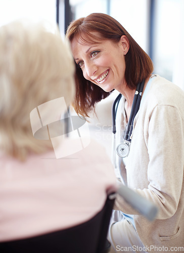 Image of A comfort to her patients in their time of need. Mature nurse has a friendly conversation with an elderly female patient confined to a wheelchair.