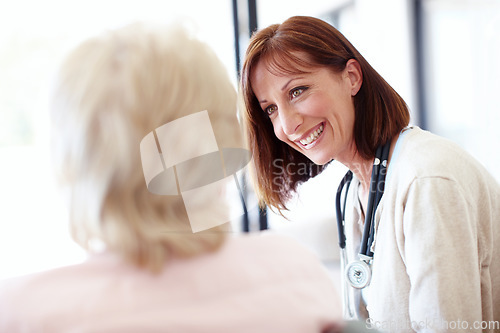 Image of A friendly follow-up - Senior Care. Mature nurse has a friendly conversation with an elderly female patient.