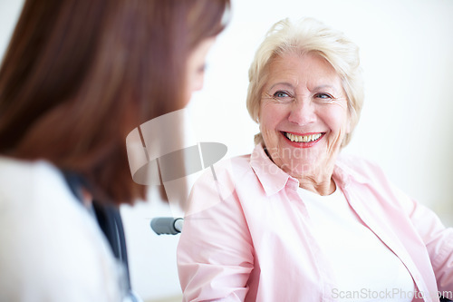 Image of Friendly doctor and patient relations - Senior Health. Senior woman in a wheelchair smiles at her friendly nurse.