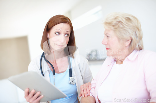 Image of Bad news delivered by a caring doctor. Mature nurse explains the outcome of her elderly patients medical tests.