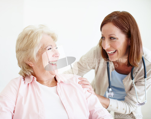 Image of Friendly banter between doctor and patient. Elderly female patient and her mature nurse share a friendly laugh together.