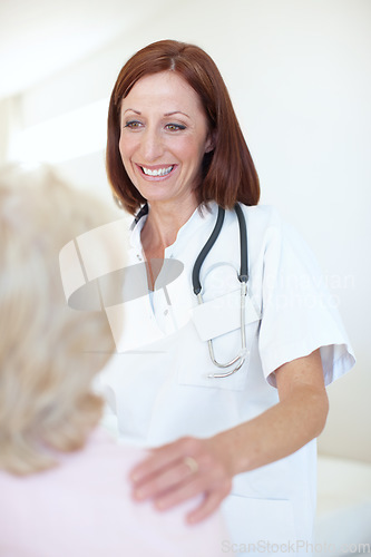 Image of She understands that every patient needs her comforting attention. Friendly mature nurse comforts her elderly patient with a hand to the shoulder.