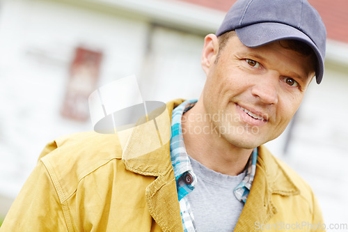 Image of Feeling positive. Portrait of casually dressed man smiling while standing outside.