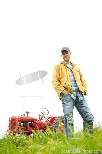 Image of One of the perks of being a farmer - Nature. Full length portrait of a farmer standing in a field with a tractor parked behind him - Copyspace.