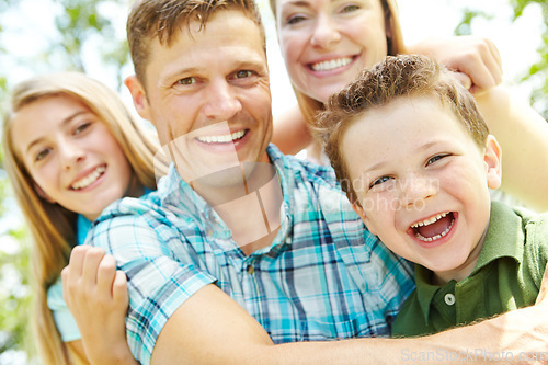 Image of They enjoy every moment together. A happy young family relaxing together on a sunny day.