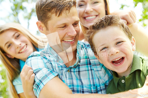 Image of Sharing laughter and smile together. A happy young family relaxing together on a sunny day.