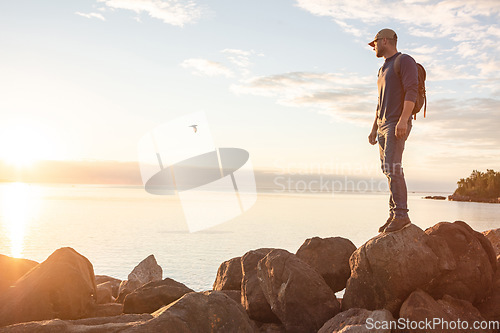 Image of The beautiful sights is my favourite thing about hiking. a man looking at the ocean while out hiking.