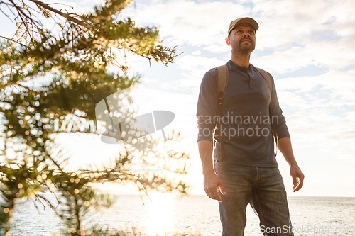 Image of I love the feeling I get when Im hiking. a man wearing his backpack while out for a hike on a coastal trail.