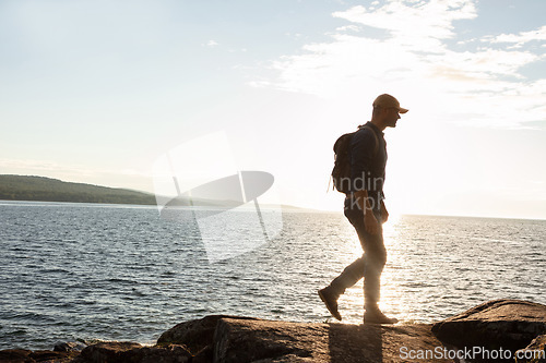 Image of Hiking will take you to wonderful places. a man wearing his backpack while out for a hike on a coastal trail.