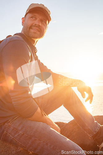 Image of Im surely enjoying myself out here. a man wearing his backpack while out for a hike on a coastal trail.