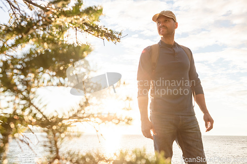 Image of Learn to live in the moment. a man wearing his backpack while out for a hike on a coastal trail.