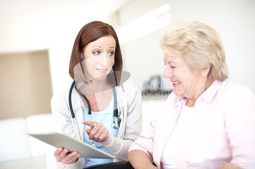 Image of Congratulations Youre in the clear. Mature nurse gives the good news to her elderly wheelchair-bound patient.