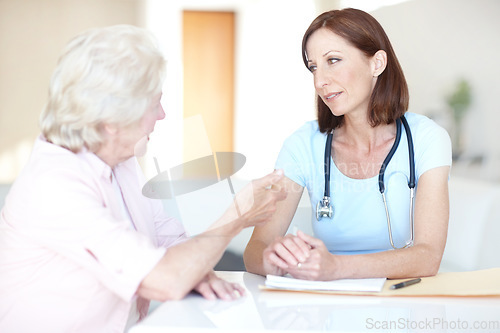 Image of Airing her medical concerns to a trusted physician. An elderly woman expresses her concerns to a trusted doctor.