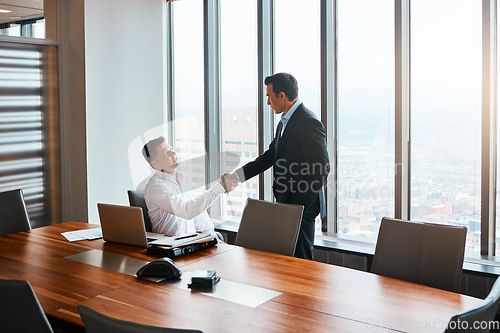 Image of Ive been looking forward to meeting you. two businessmen shaking hands in a corporate office.