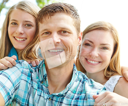 Image of Proud of his beautiful family. A happy young family relaxing together on a sunny day.