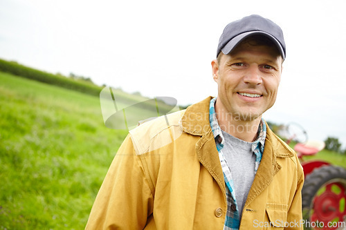 Image of I love my job. Portrait of a smiling farmer in a field with a tractor parked behind him - Copyspace.