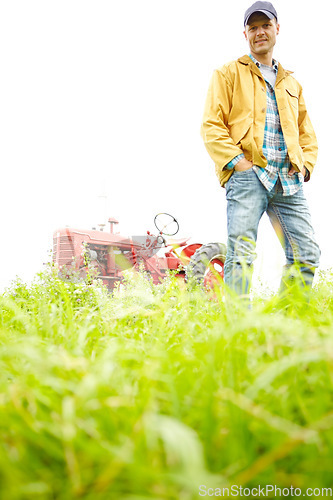 Image of My average working day. Full length portrait of a farmer standing in a field with a tractor parked behind him - Copyspace.