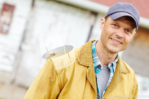 Image of Hes a positive kind of man. Portrait of casually dressed man smiling while standing outside.