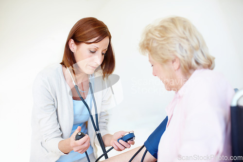 Image of Getting the readings on her patients blood pressure. Mature nurse checks an elderly female patients blood pressure.