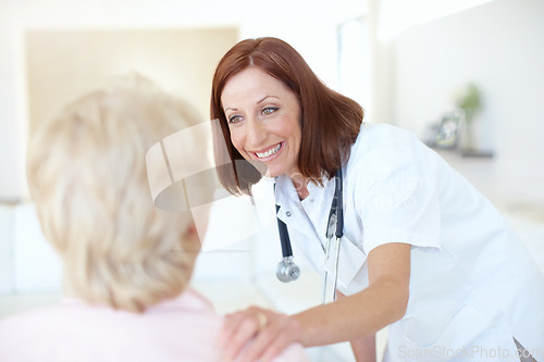 Image of A quick checkup on a patients progress. Friendly mature nurse comforts her elderly patient with a hand to the shoulder.