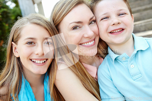 Image of We couldnt be any closer. Smiling attractive mother embracing her teen daughter and young son while outdoors.