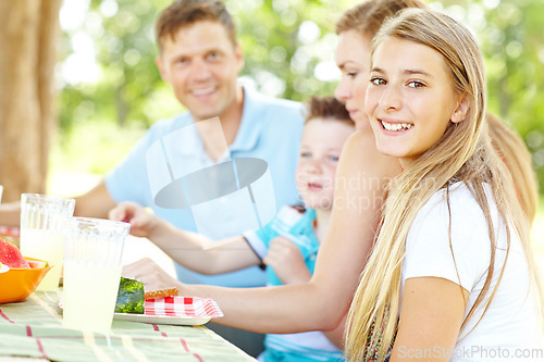 Image of Enjoying a summer picnic together. A happy young family relaxing in the park and enjoying a healthy picnic.