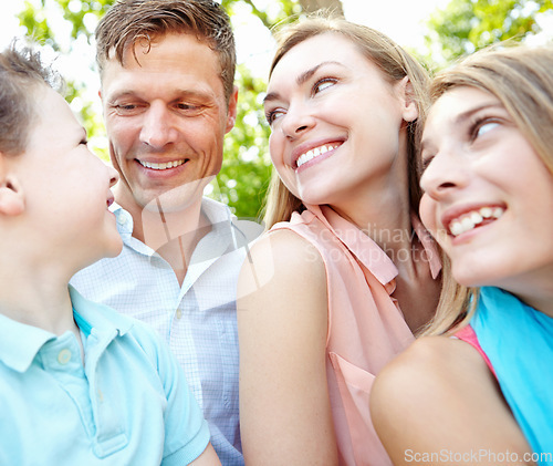 Image of Family afternoon in the park. Happy family smiling while outdoors.