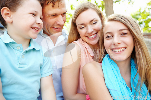 Image of Spending time together in the park. Happy family smiling while outdoors.