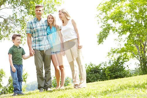 Image of Appreciating the scenery together. A happy family standing together in the park on a summers day.