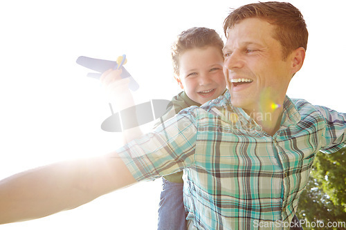 Image of Lets go faster and higher. A cute little boy playing with an airplane while being carried on his fathers back.