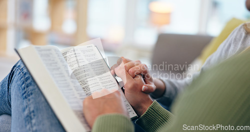 Image of Couple holding hands, bible and closeup in home for reading with faith, spiritual knowledge and bonding. People, zoom and book for hope, worship or connection to God in living room for peace in house